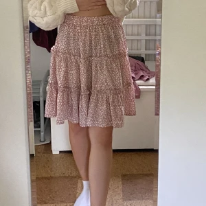 Rosa kjol  - Rosa kjol med mönster, sitter bra runt midjan då den har ett gummiband. 