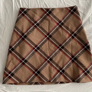 Rutig kjol - Midjehög kort kjol. Dubbeltyg med en silkeslik insida. Endast använd en gång ☺️