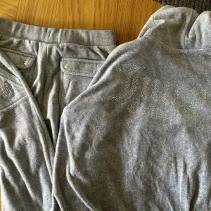 Fint ljusgrått juicyset. Byxorna är i storlek 13-14 år och tröjan 15-16 år. Det syns att det är använt men fortfarande i fint skick. Tvättat enligt rekommendationerna. 