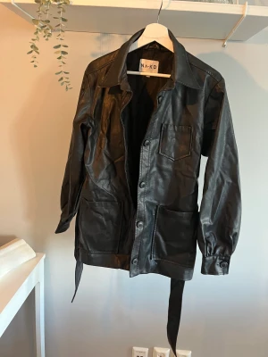 Skinnjacka - Skinnjacka med knytning i midjan.