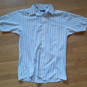 En randig skjorta som har ett jätte litet hål som knappast syns men annars i bra skick 