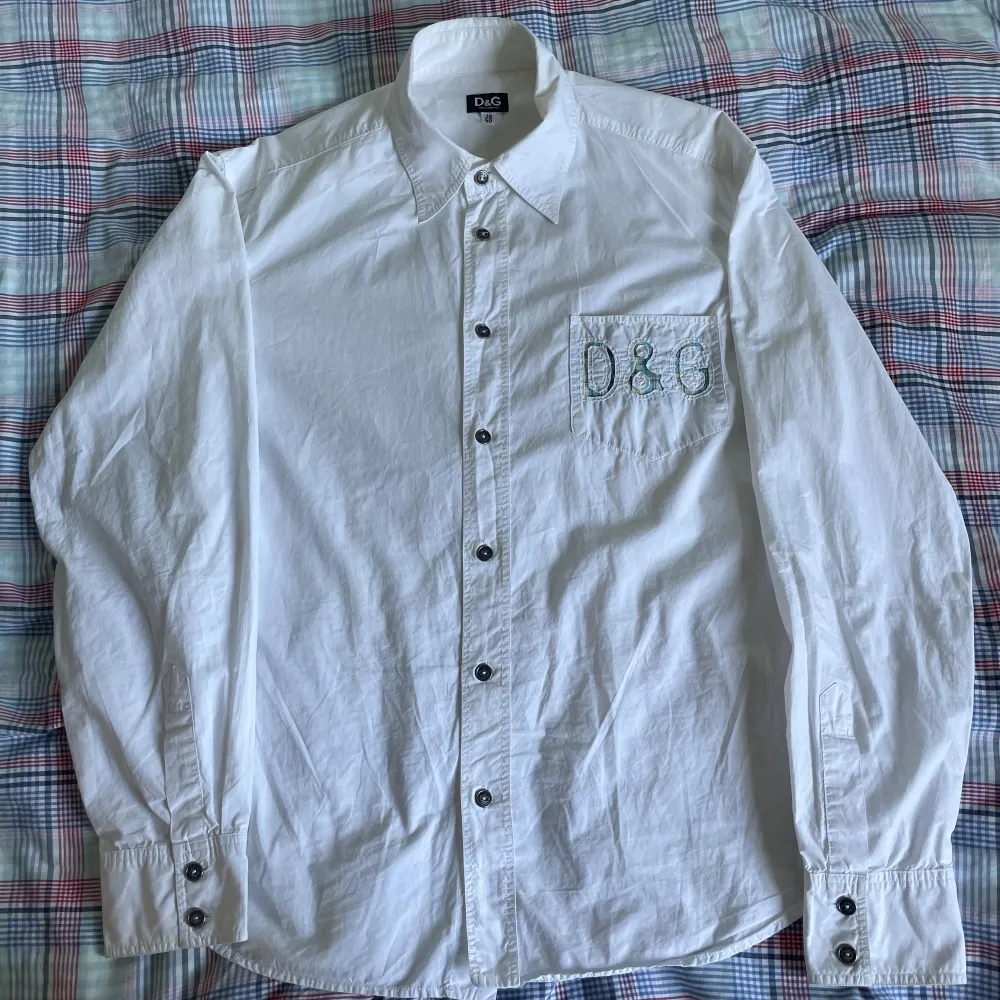 Vintage D&G skjorta i vit färg med märkesdetalj på bröstfickan. Lite oversized fit skulle tippa på att den är strlk S-M typ, på tagen står det 36/50. Tydliga tecken på en tidigare ägare fast den är i ett ganska bra skick skulle säga 7,5/10. Skjortor.