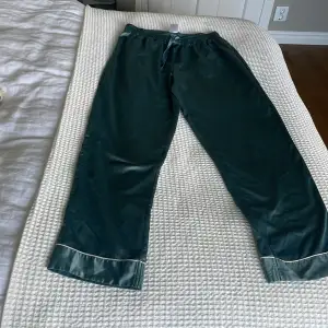 Ett par super fina gröna silkes pyjamasbyxor med en liten vit kant på benet. De har en söm som dragits ut på låret så är ett litet streck men inget man tänker på så mycket💚
