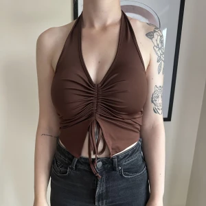 Brun halternecktopp - Brun halternecktopp med scrunch i fram. Från Bik Bok, storlek S. Använd 1 gång. Nypris 179 kr. 