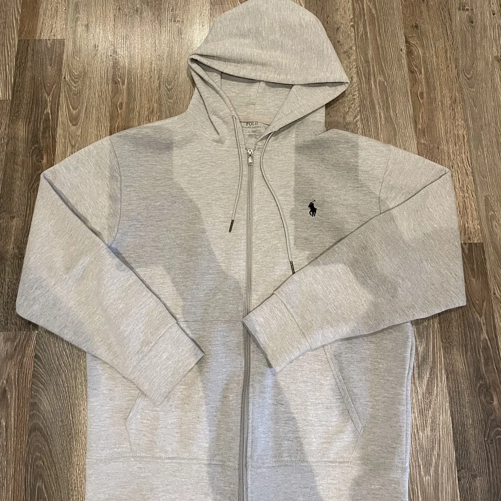 Säljer denna Ralph Lauren zip hoodie då den är lite liten. Den är i bra skick förutom att det har lossnat en metallsak vid luvan (se bild). Den är i storlek M och är köpt här på plick för cirka 4 månader sedan.. Hoodies.