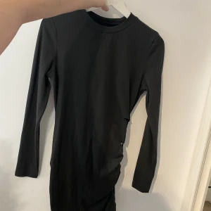 Svart klänning - Svart långärmad klänning, du knyter själv hur öppet du vill ha på sidan. oanvänd. använd köp nu❤️FRI FRAKT FRÅN 30onde-6e nov via köp nu