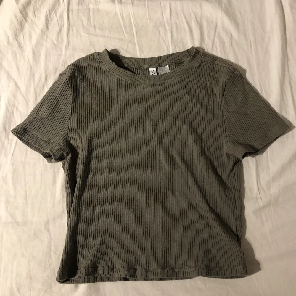 Ribbad militär/oliv grön croptop från H&M, säljs inte längre vad jag kan se, inprincip oanvänd/använd cirka 2 gånger. Stretchigt tyg & passar M-S jättebra, sjukt fint färg, sista bilden är tröjan på 🫶 går precis över naveln på mig! hör av dig vid frågor ❤️. Toppar.