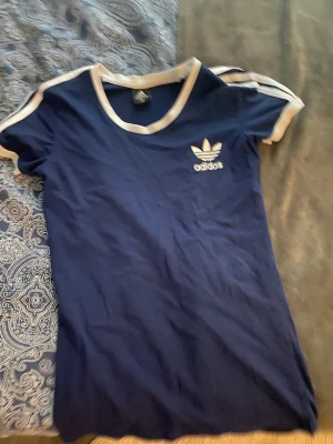 Tight navy adidas tshirt - En mörkblå adidas tshirt som formar kroppen. Är väl en träningströja men har inte det materialet. Har aldrig används till träning. Väldigt fin och sparsamt använd. Skriv vid frågor❤️