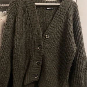 Grön stickad cardigan - Säljer en super fin och mysig mörk grön stickad cardigan. Storlek XS men skulle nog säga att den sitter som en S, jätte fin och sticker inte alls.  