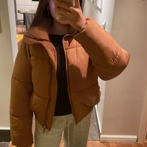 Puffer jacket - Säljer denna orange/bruna pufferjackan som är i fint skick utan defekter och är super varm och skön! Kommer med avtagbar luva!!❣️