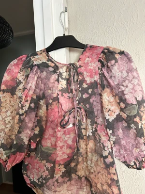 Blus med puffärmar  - Blus med puffärmar i gott skick. Storlek Medium. Halvt öppen rygg med snörning. 