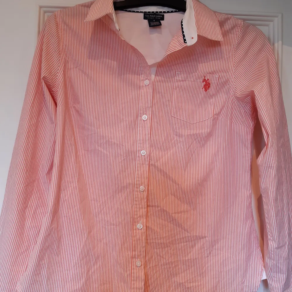 Skjorta från Polo Ralph Lauren i storlek S. Sparsamt använd och i mycket fint skick.   Det saknar en knapp näst längst upp på skjortan som man kan se på bild 3. Men det är inget som man tänker på när man har på sig den.. Skjortor.