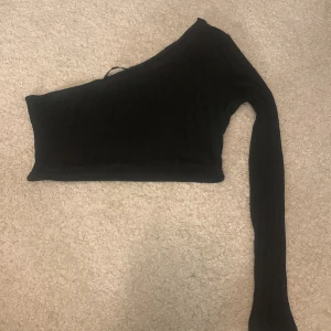 En arm topp - Svart kort topp från SHEIN som bara har en ärm, använd fåtal gånger.