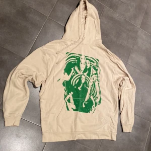 Subdued beige Hoodie med grönt tryck fram, stl S - Subdued beige hoodie med grönt woman-tryck fram, fint skick, sparsamt använd, stl: S