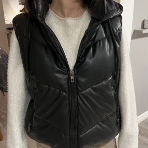 Skinnväst  - Min super snygga fake skinn väst säljs pga den inte kommer till användning, den är köpt från zara och är som ny. Perfekt till hösten då man inte kan förutse väder då den har en luva. 