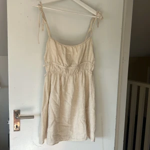 Linne klänning - Linne klänning från Pull&Bear. Använd en gång. Öppen i sidorna. 