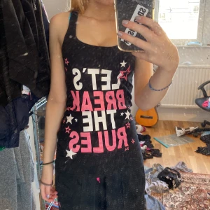 Skit snyggt linne - Svart linne med rosa och vitt tryck, storlek S/M skulle jag säga. Har ett litet hål på ryggen men inte så synligt.  Skriv för fler bilder eller frågor💗