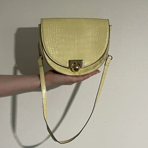 Axelväska  - En fejk krokodilväska med guld kedjor som går att förlänga och förkorta✨ Köpt via secondhand. Knappt använd. Det finns repor på guldknappen.