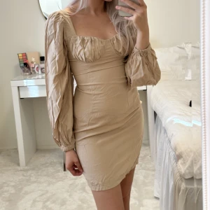 Klänning - Beige klänning med puffärmar. Oanvänd, endast testad.
