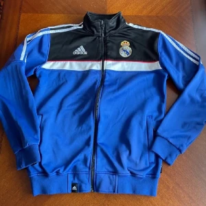 Real Madrid kofta - Tjena. Säljer nu min Real Madrid kofta som kan användas som en vanlig kofta eller till träning. Skönt material och väldigt fin. På några sömmar på axlarna har tråden försvunnit. Inget som man tänker på. Storlek S men ganska stor i storleken.