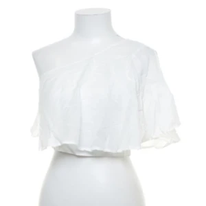 Volang croptop enarm - Supersöt croptop med lite volanger från NA-KD!!   Sätts på med en dragkedja på sidan som täcks av tyget. Köpt på sellpy med prislapp från både NA-KD och Sellpy   Jättesöt inför sommaren!