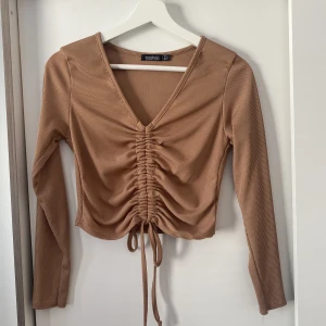 Topp - Långärmad topp med snöre från boohoo. Kommer inte till användning. Storlek 36/S pris 150kr. Skriv för mer info!