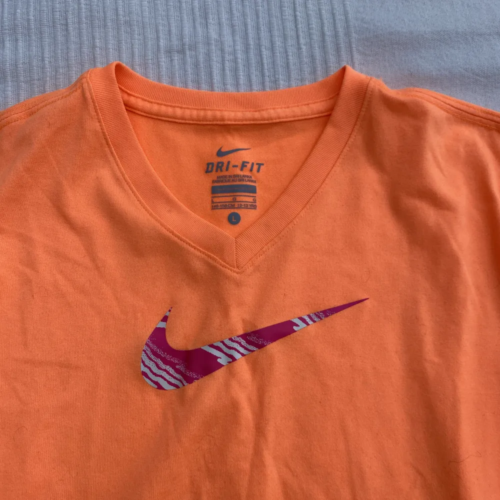 Orange tränings T-shirt från Nike med rosa logga! Jättesnygg och bra skick bara smått nopprig men syns knappt! Den är L i barnstorlek men funkar som en S för vuxna också. Jag har S och kan ha den utan problem.. Hoodies.