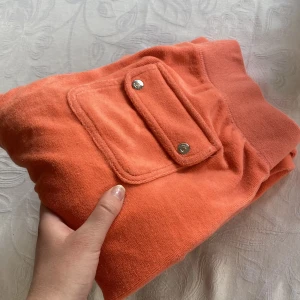 Juicy byxor - Säljer nu dessa byxor då jag inte kände att jag fick något bra byte, Juicy couture byxor i orange, ena ”pluppen” på snöret saknas. Storlek S. 💕 obs materialet är mer ”towel material”. 
