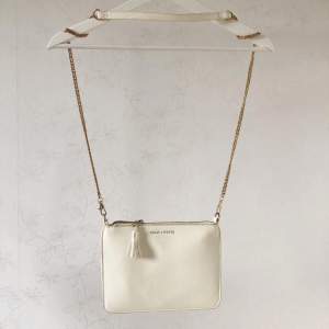 Off white kuvertväska med avtagbar guldkedja. 23x17cm
