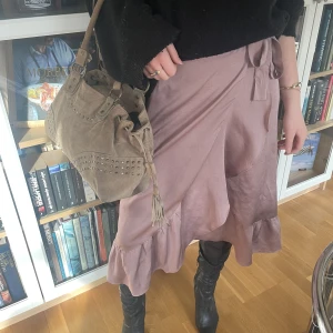 Lång kjol - Volangkjol i rosa. Knytbar och passar därför alla storlekar. Nypris 649kr.