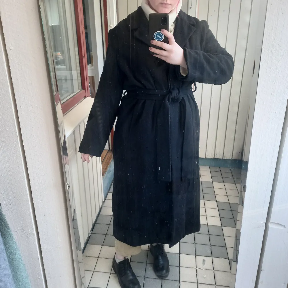 A light ankle length overcoat. Has three buttons and nice spacious pockets!  Size L. Length 130 cm. Shoulder width 48 cm. Underarm width 62 cm. Sleeve length (from the shoulder) 60 cm.  The shell fabric is thin, but dense and soft. Good for -3..+8°C.. Jackor.