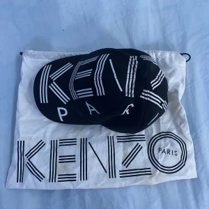 KENZO PARIS KEPS - Kenzo paris keps-ny pris 1000kr+. Säljs för används inte längre, OBS liten gul fläck på påsen men ska tvättas! Om mer frågor eller behov av mer bilder, skicka ett meddelande privat! (Kepsen är i ny skick!) Kepsen passar inpinsip alla huvuden.