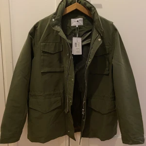 NN07 Field Jacket - NN07 Filed Jacket. Färg:Army Stl: L Aldrig använd, prislapp kvar. Nypris 3199kr