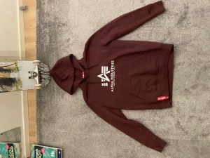 Alpha Industries hoodie - Säljer min Alpha hoodie då jag renar ur min garderob och insåg att den va för liten. Färg är Deep maroon. Storlek M. Mitt pris 300kr nypris 800kr skick bättre än bra kanske mycket bra då jag inte har använt den så mycket.