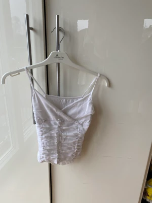 Vit linne med rosetter  - Ett vit linne från okänd märke men det är ifrån Italien säljs. Är i stl xs/xxs. Köparen står för frakt.