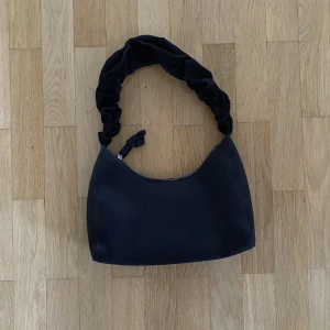 Väska - Säljer denna superfina svarta väska från nakd. Använd endast ca 5 gånger så i nyskick. Den är ca 30 cm bred❤️