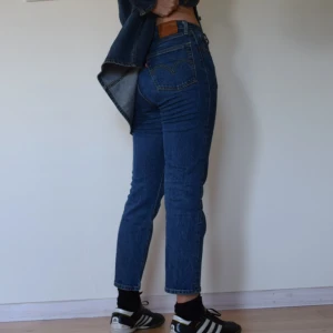 Levi’s 501 - Levi’s 501 Strl: W27L26 Mått: benlängd innersöm 65cm, midja 76cm, benöppning 18cm  Material: 99% bomull, 1% elastan   Modell: 501’s, mom jeans, normal midja Skick: använt skick, se bild 3 för viss slitning på bakfickorna