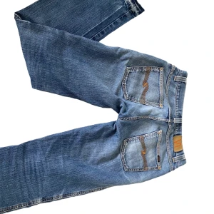 Supersnygga Nudie jeans! - Köpta på en loppis för ungefär ett halvår sedan och sparsamt använda. De är lågmidjade och bootcut/raka. Vid fickan är det lite slitet men ingenting som ”förstör” då det finns mycket tyg där, även ett hål på höger ben!💓Priset kan diskuteras! 
