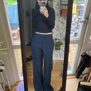 Rutiga kostymbyxor  - Rutiga kostymbyxor i blå/grön färg, tror dom kommer från Zara. Dom är lite insydda i midjan, även sytt fast en extra knapp där man knäpper.  långa i benen. Vet inte vilken storlek men jag är vanligtvis 34/36 och dom sitter lågmidjat, passar avsolut större