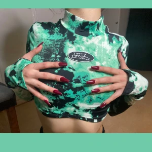 Croppad långärmad topp - Långärmad croptop köpt från H&M aldrig använd (H&M X NO FEAR) finns inte att köpa längre💅🏻 Cool neon grön färg m.m, skitsnygg rave topp om något 🥵 No Fear är ett märke som var populärt mitten av 90 talet och tidigt 2000⭐️ 