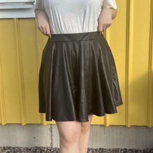 En svart lite glansig kjol från Boohoo. Resår i midjan. Jag är 165cm så den är ganska lång på mig. 