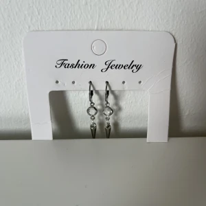 Örhängen - Ett par superfina handgjorda örhängen som är nickelfria. Örhängena består av ringar och en diamant i mitten och en nit i botten, se bilden ovan🔝 skriv vid intresse eller frågor🫶🏻