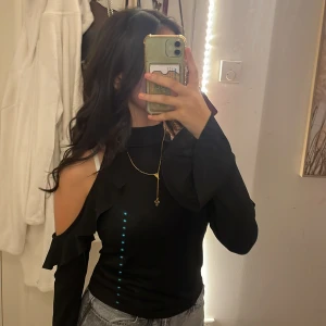 Svart tröja med hål i axlar  - En svart tröja med vida armar och hål i axlarna. Väldigt fin, använt någon gång på nyår annars oanvänd. Köpt för 199kr. Pris kan diskuteras!