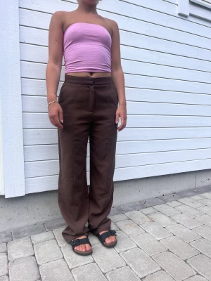 Kostymbyxor från NA-KD, som nya.  - Bruna kostymbyxor från kollektionen ”Angelina blick”. Väldigt långa. Storlek 36 men passar även 38