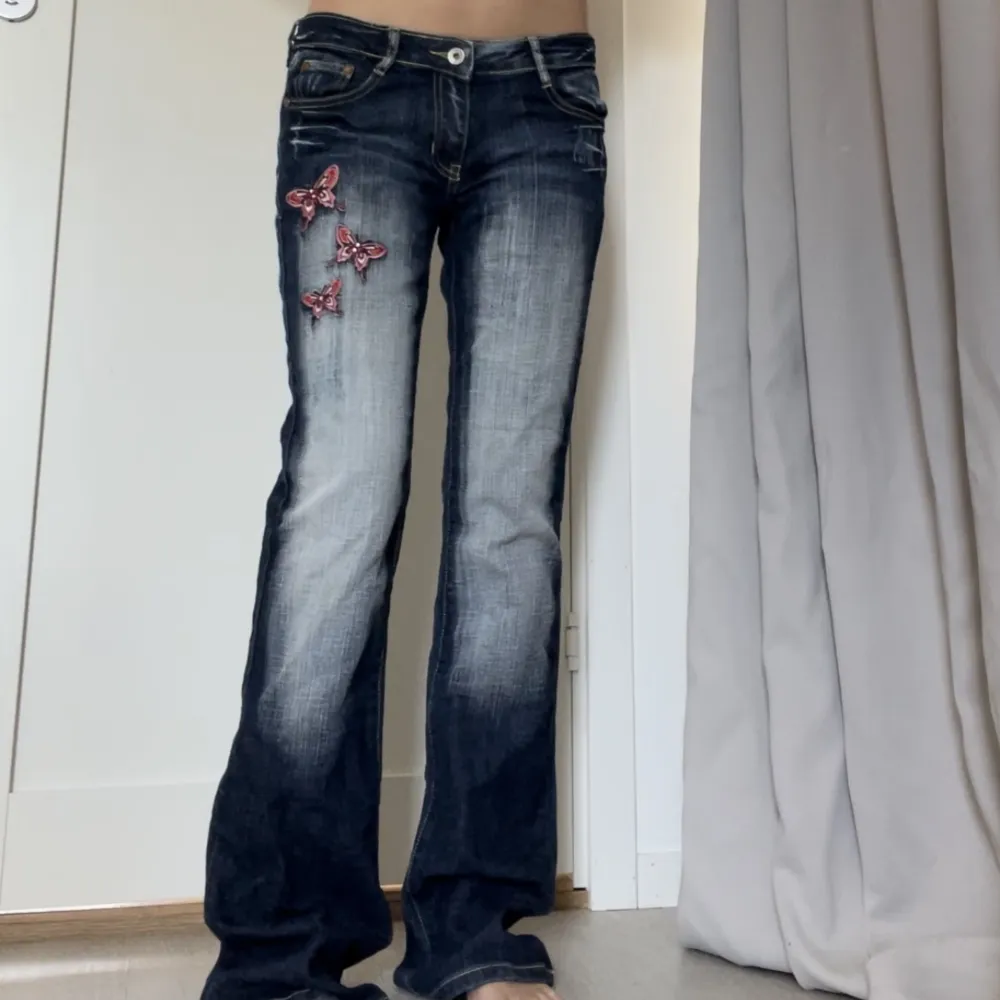 Lågmidjade jeans med bootcut/flare och broderade fjärilar💘 Crazy Age stil, bra skick!🌟 Mått: midja: 38cm(x2), innerbensmått: 85cm, midjehöjd: 19cm💞. Jeans & Byxor.
