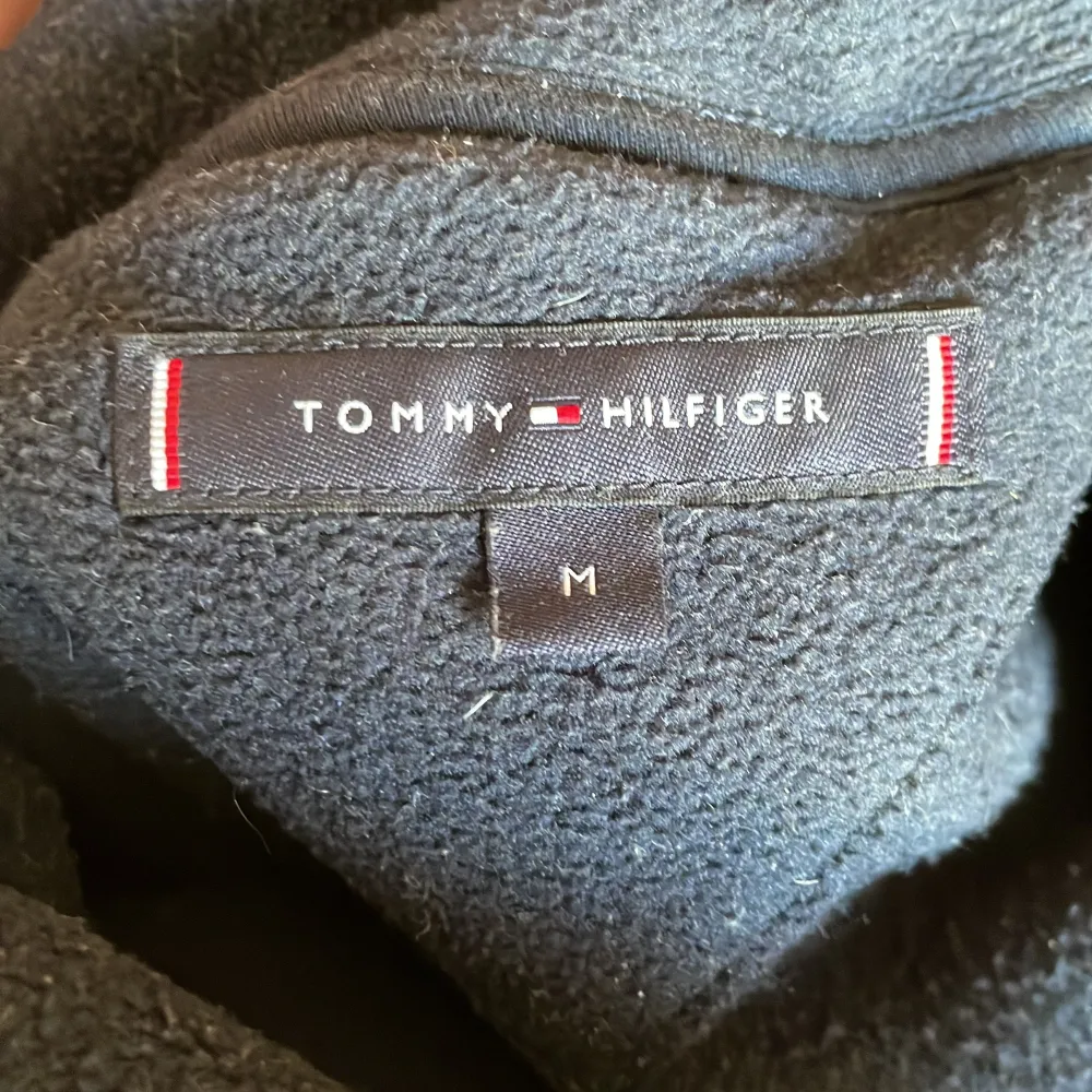 Säljer en Tommy hilfiger flis. Den är lite tjockare än en vanlig hoodie vilket gör den riktigt skön att ha på kalla dagar när det är skit väder. Den är i storlek M och är perfekt för folk som är 175-190cm. Jag är själv 188cm och den sitter bra på mig . Hoodies.