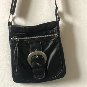 svart axelremsväska  - super cool svart axelremsväska köpt här på plick. aldrig använd av mig och i perfekt skick. justerbar rem också. läs bio innan köp 🌱📿