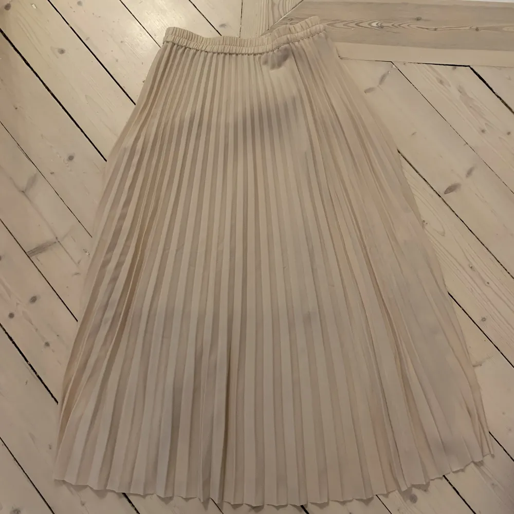 Krämfärgad plisserad kjol från Selected Femme, använd ett fåtal gånger. Nypris 800kr. Kjolar.