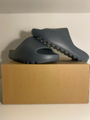 Yeezy slide slate marine - Säljer mina yeezy slide slate marine i storlek 43. Pris: 1100 men det är ej hugget i Sten. De är Deadstock alltså aldrig använda.