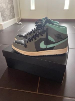Jordan 1 Grey Agua ”Mid” - Hej, jag säljer mina Jordans då jag inte använder dem lika mycket längre. Jag köpte dem från ”Merchsweden” för 4 499kr. Skorna är lite slitet på ena sulans häl och lite färg har gått bort på inre utsidan av skon(inget man ser). Kom priv för bilder o frågo